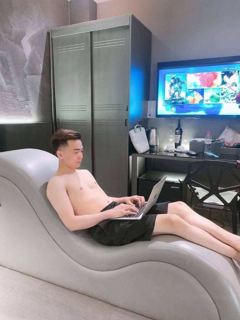 Young Vietnamese creator editing YouTube videos on laptop