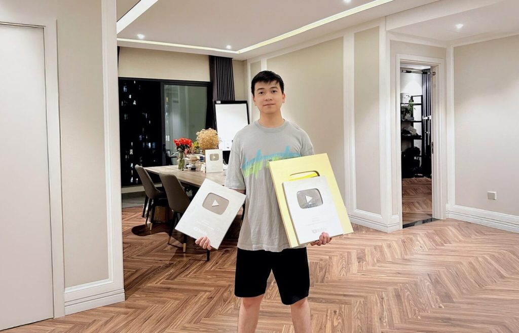 YouTuber holding YouTube Creator Awards in a modern home office, showing a seven-figure channel milestone - Don Ninh